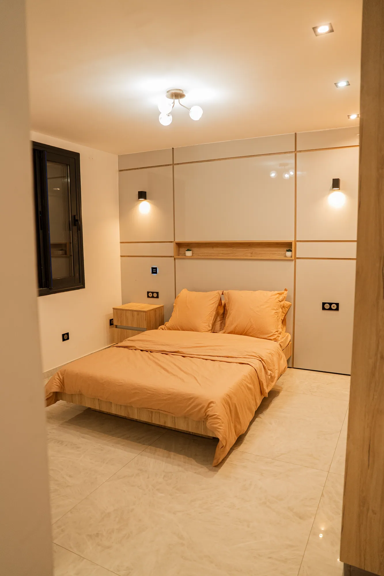 Chambre en lumière chaude, tête de lit panneautée