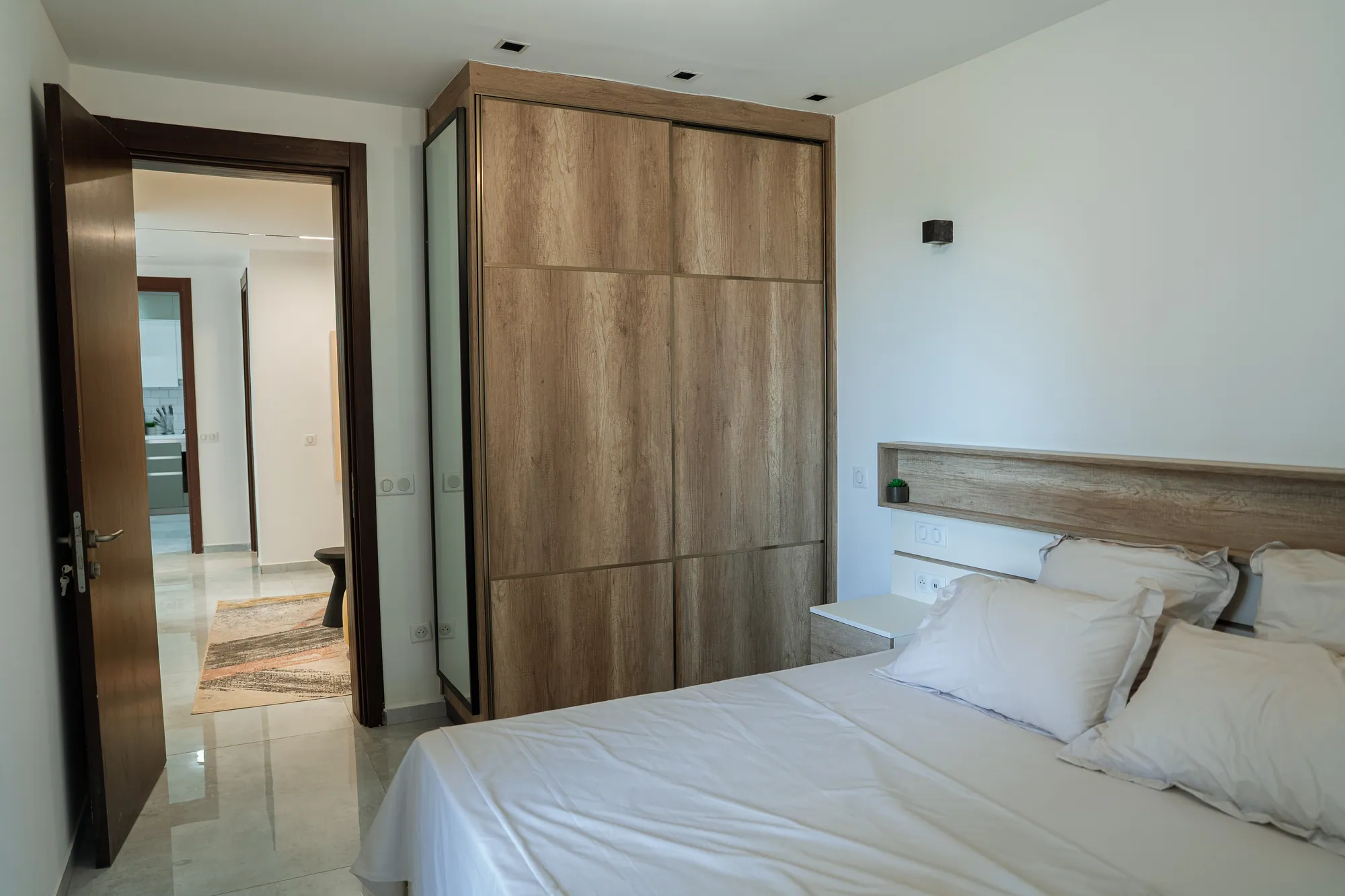 Chambre, penderie et enfilade vers l'entrée