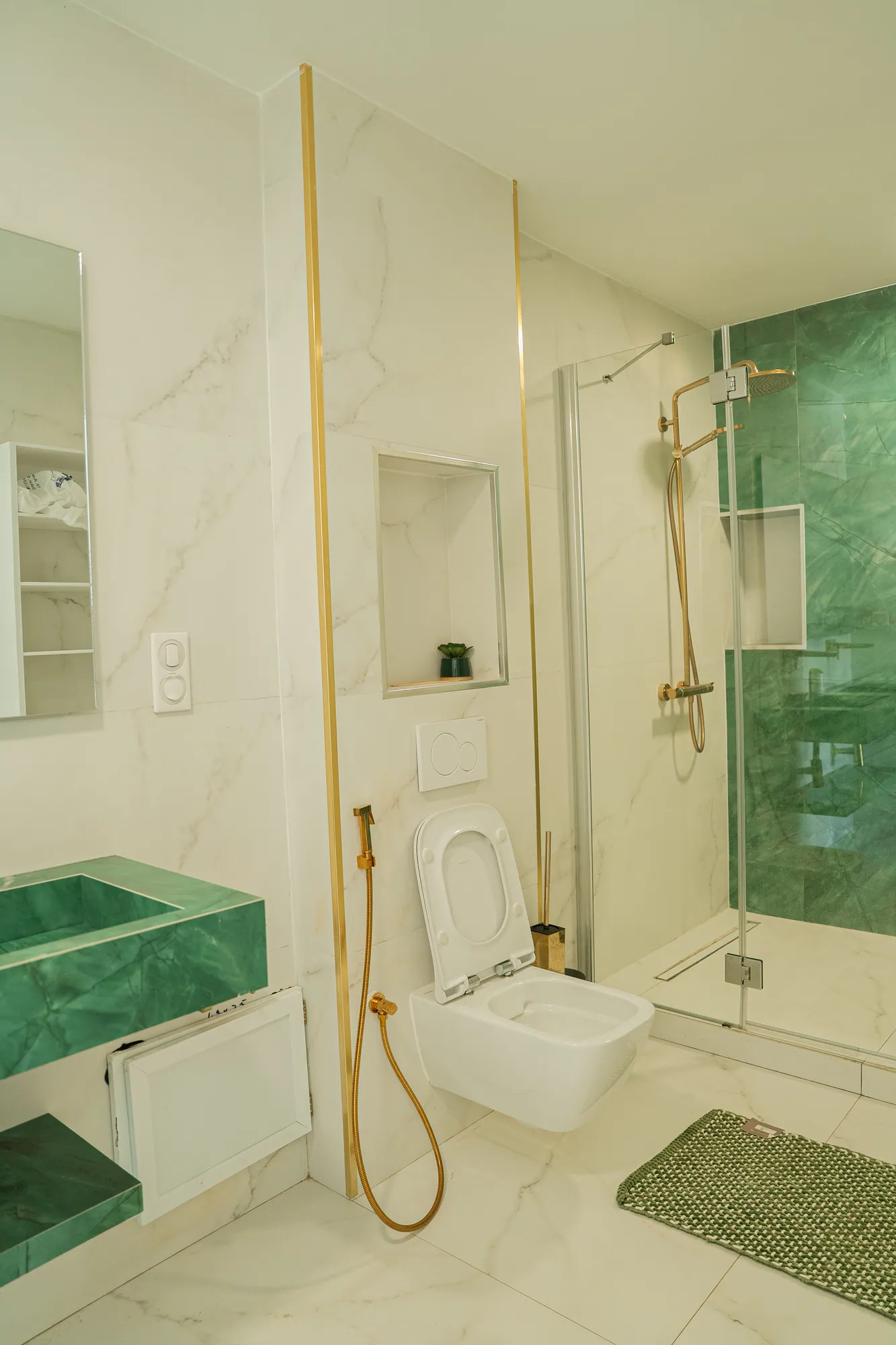 Salle de bain plaquée d'onyx vert et robinetterie dorée